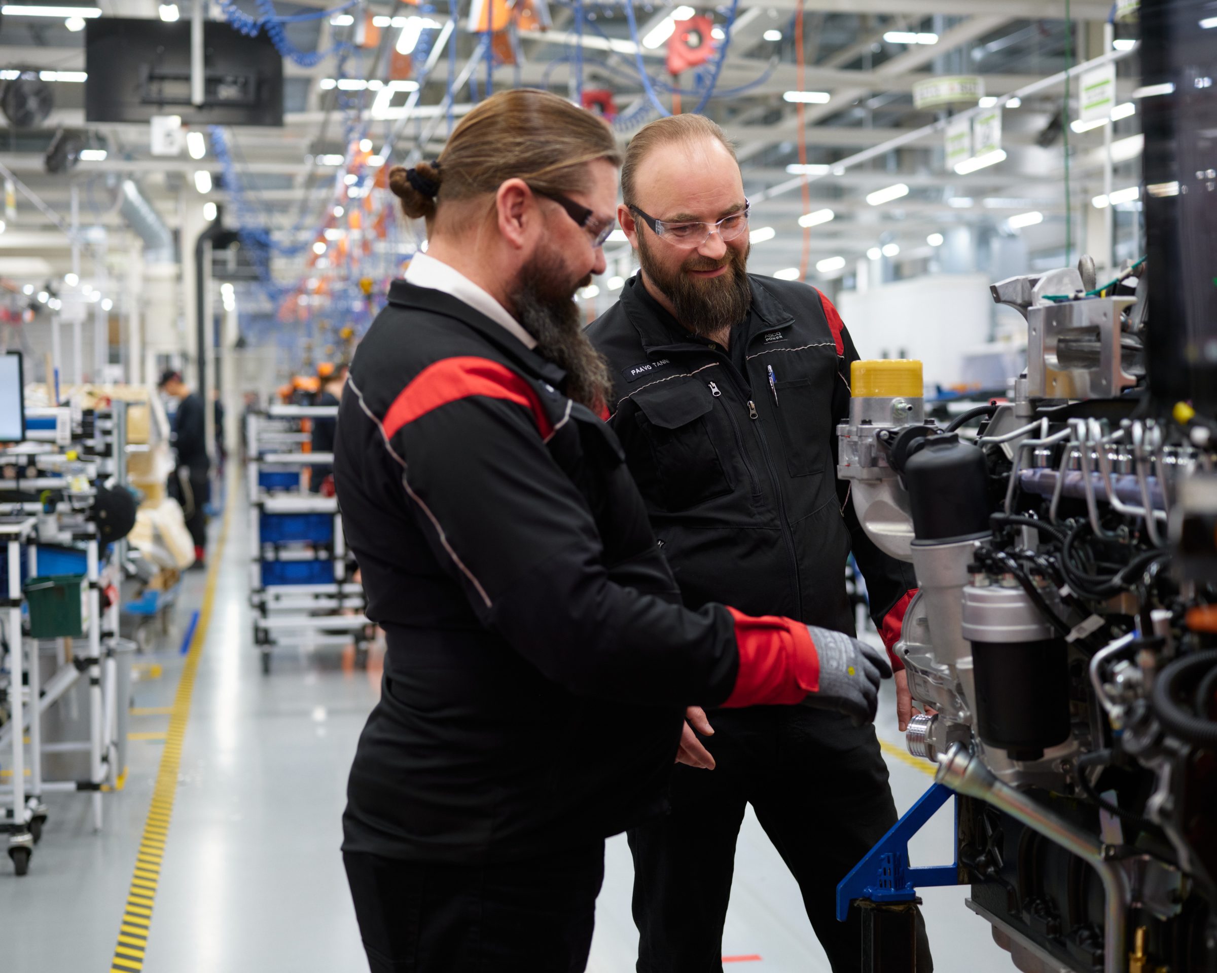 The photo features Senior Design Engineer Jari Kaste and Production Manager Paavo Tanni.